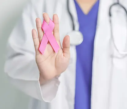 Breast cancer specialist holding pink ribbon for awareness